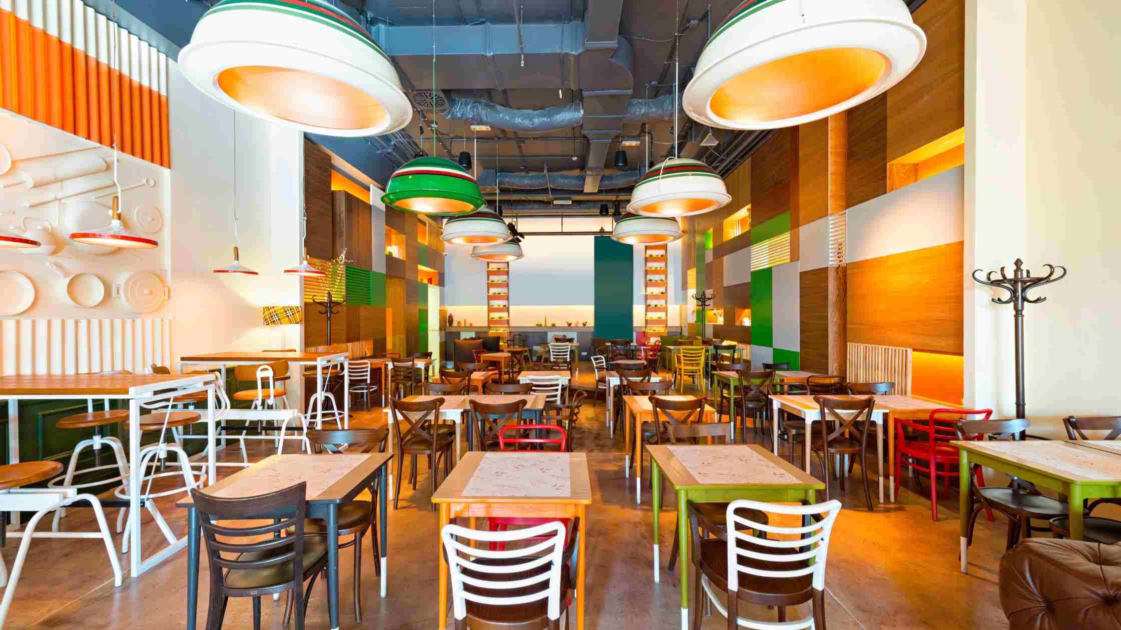 Vibrant restaurant interior with multi-colored wood panels and warm lighting, using restaurant colour design to create an inviting atmosphere for the modern customer.